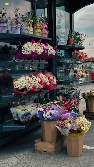 An outdoor floral display at flowerstulsehill.co.uk features an array of vibrant bouquet arrangements on a multi-tiered metal stand. The bouquets include pink, white, purple, and yellow flowers, such 